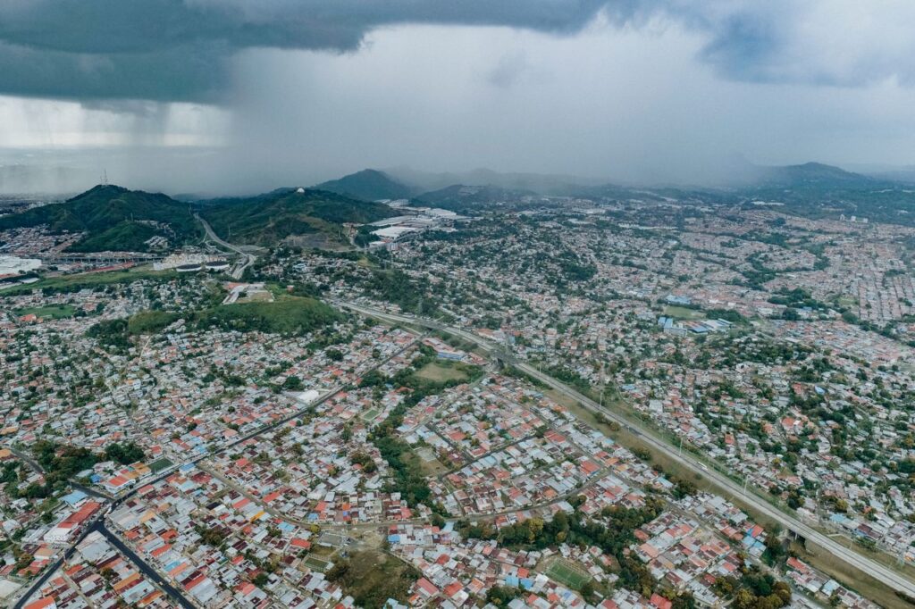 Aerial view of Panamá City showcasing extensive urban sprawl beneath a dramatic stormy sky.