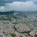 Aerial view of Panamá City showcasing extensive urban sprawl beneath a dramatic stormy sky.