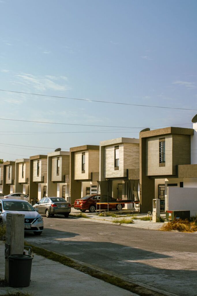 A view of modern suburban houses with parked cars on a sunny day in Monterrey, Mexico.
