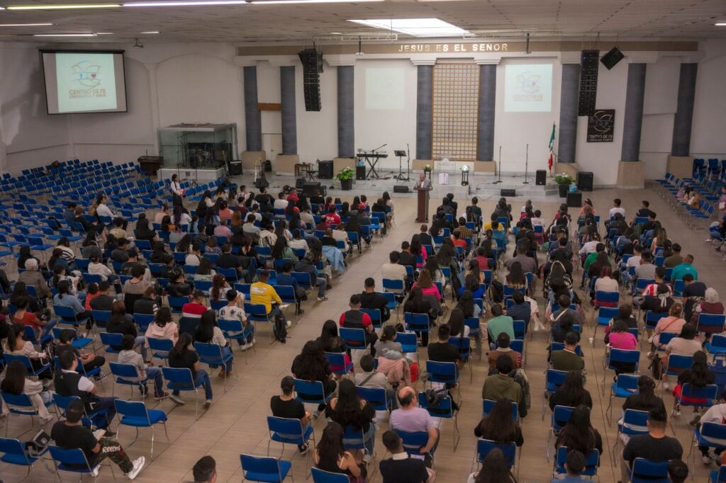 A large audience seated in a church auditorium attending a seminar.