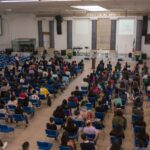 A large audience seated in a church auditorium attending a seminar.