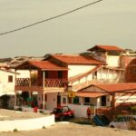 A picturesque view of traditional Brazilian beach houses under a clear sky.