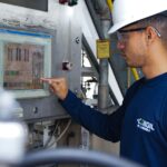 Engineer using control panel at industrial facility, ensuring operational efficiency.