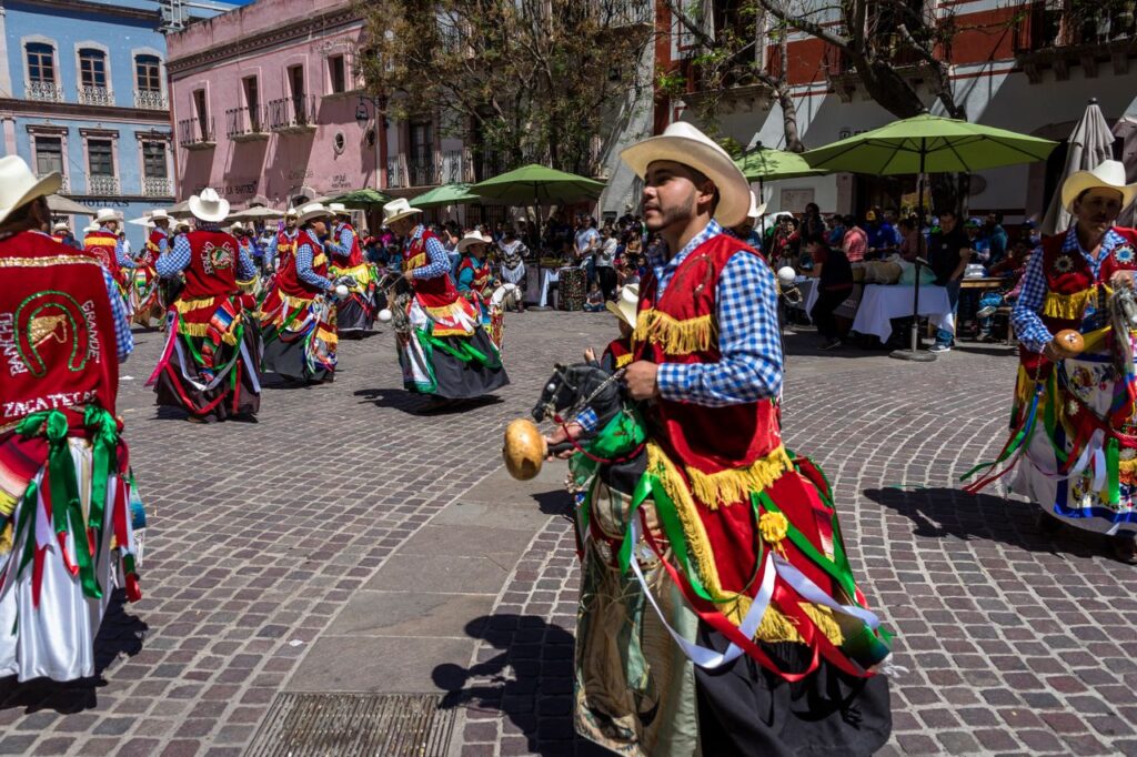 Colorful traditional dancers celebrating Mexican heritage in a lively town square.